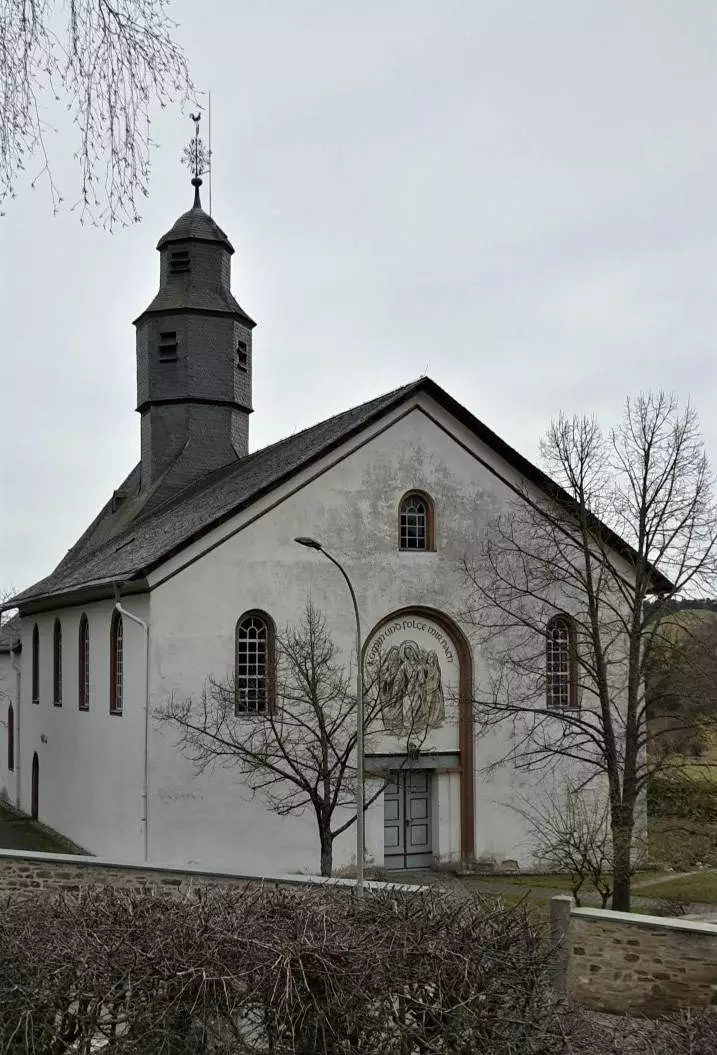 Eine Kirche mit einem Kirchturm mitten auf einem Feld.