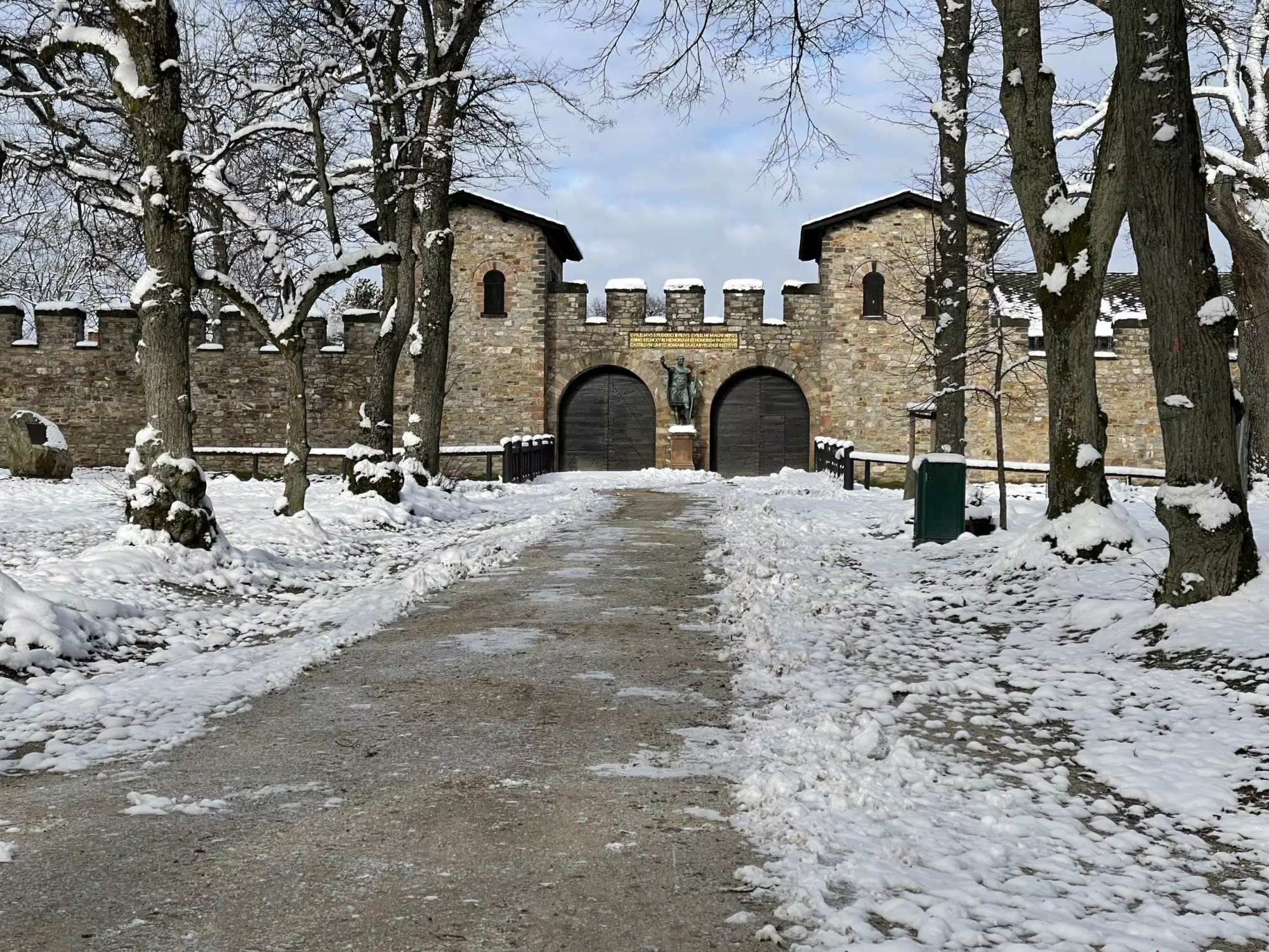 Ein schneebedeckter Weg, der zu einer alten Burg führt.