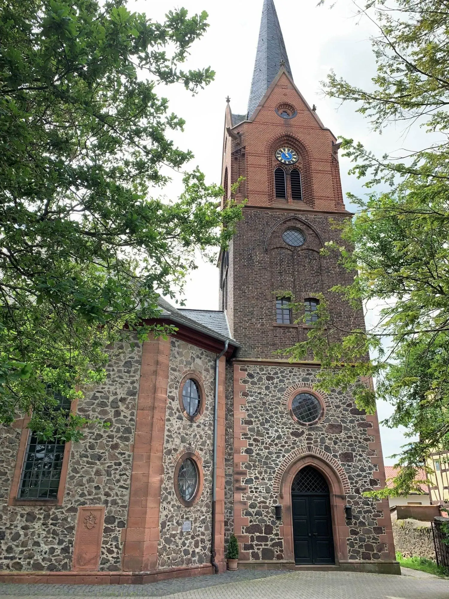 Eine Kirche mit Turm inmitten eines Waldgebietes.