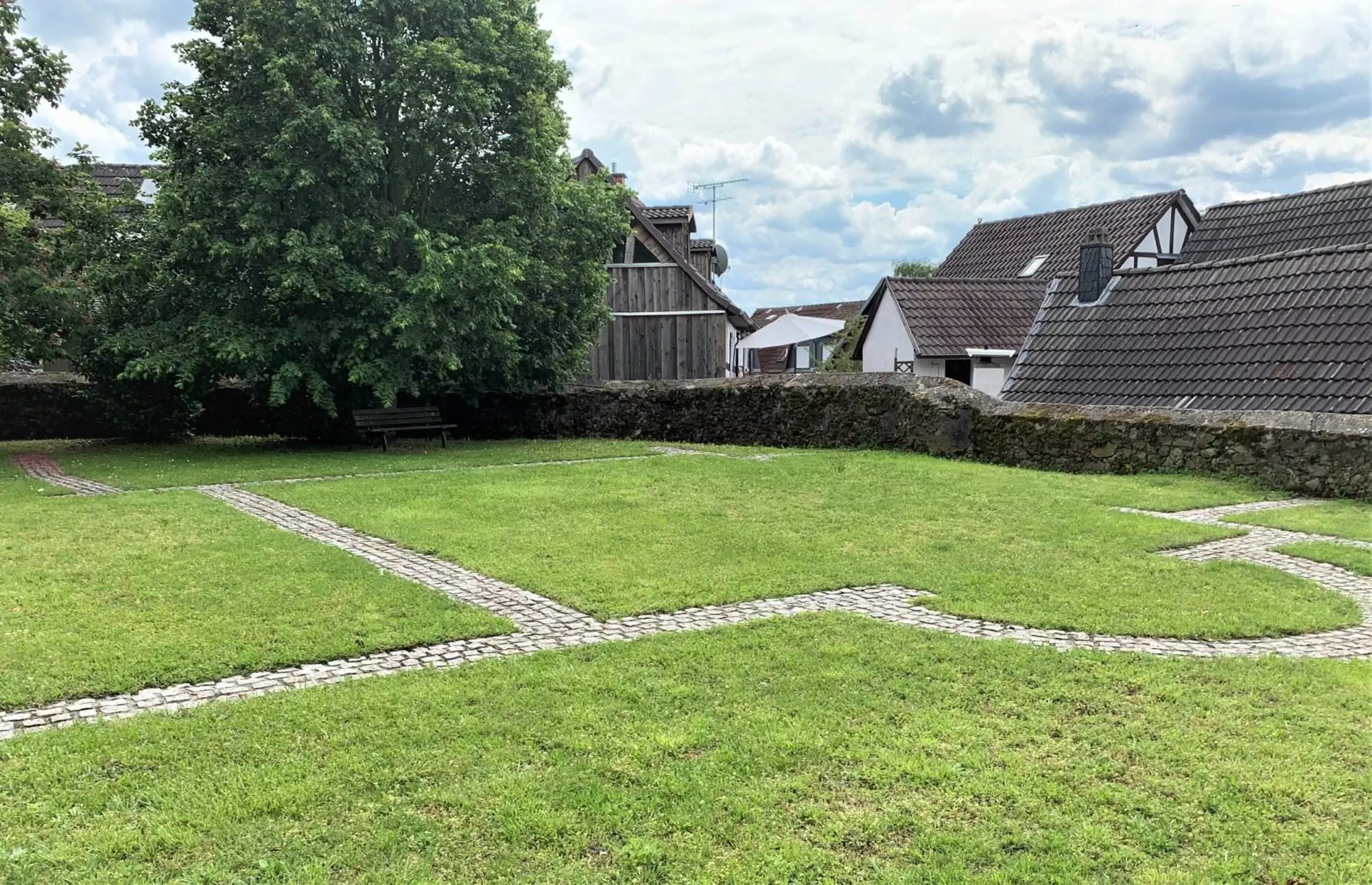 Eine Rasenfläche mit einem Steinweg vor einem Haus.
