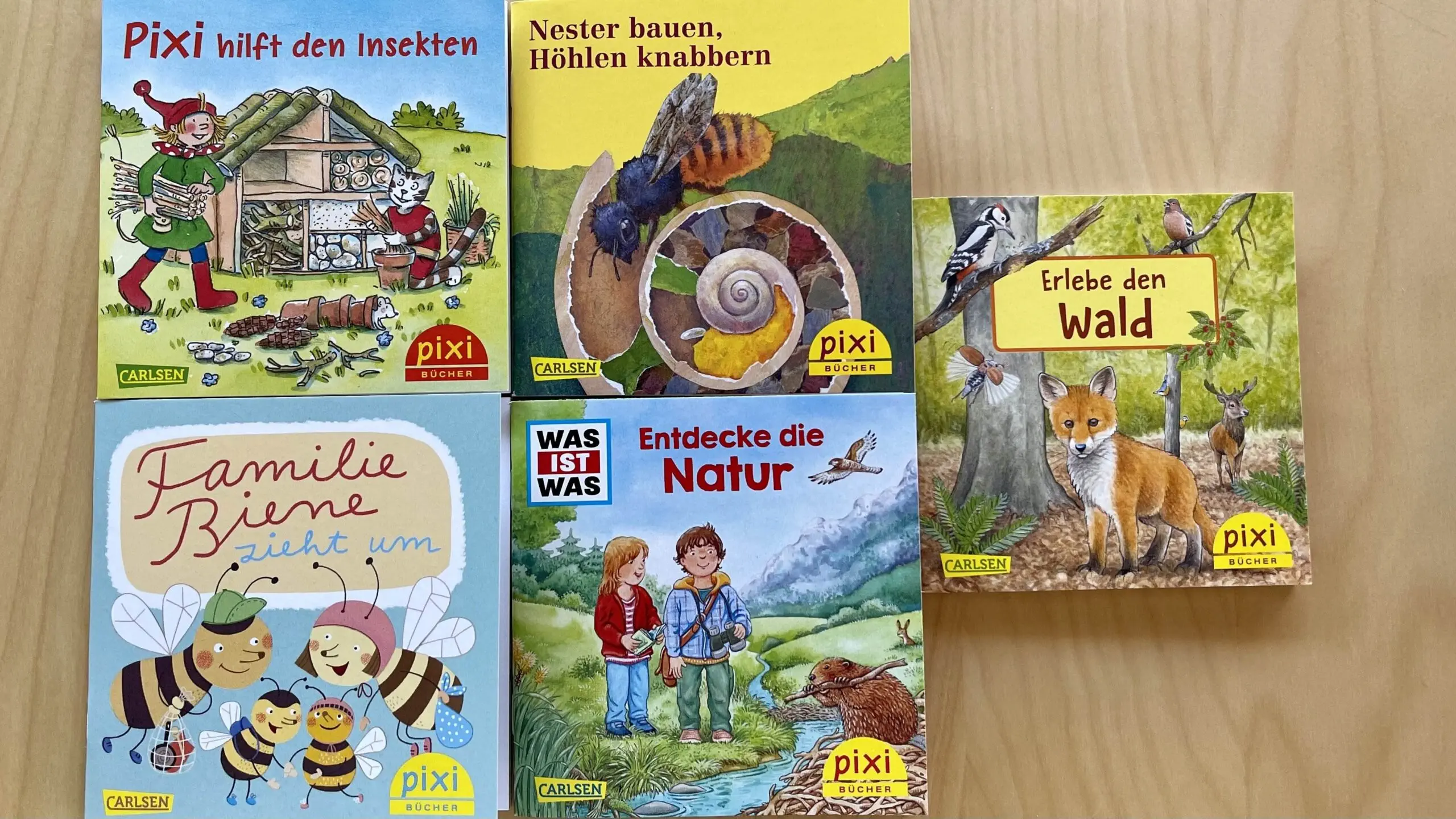 Fünf Pixi Kinderbücher auf einem Holztisch.